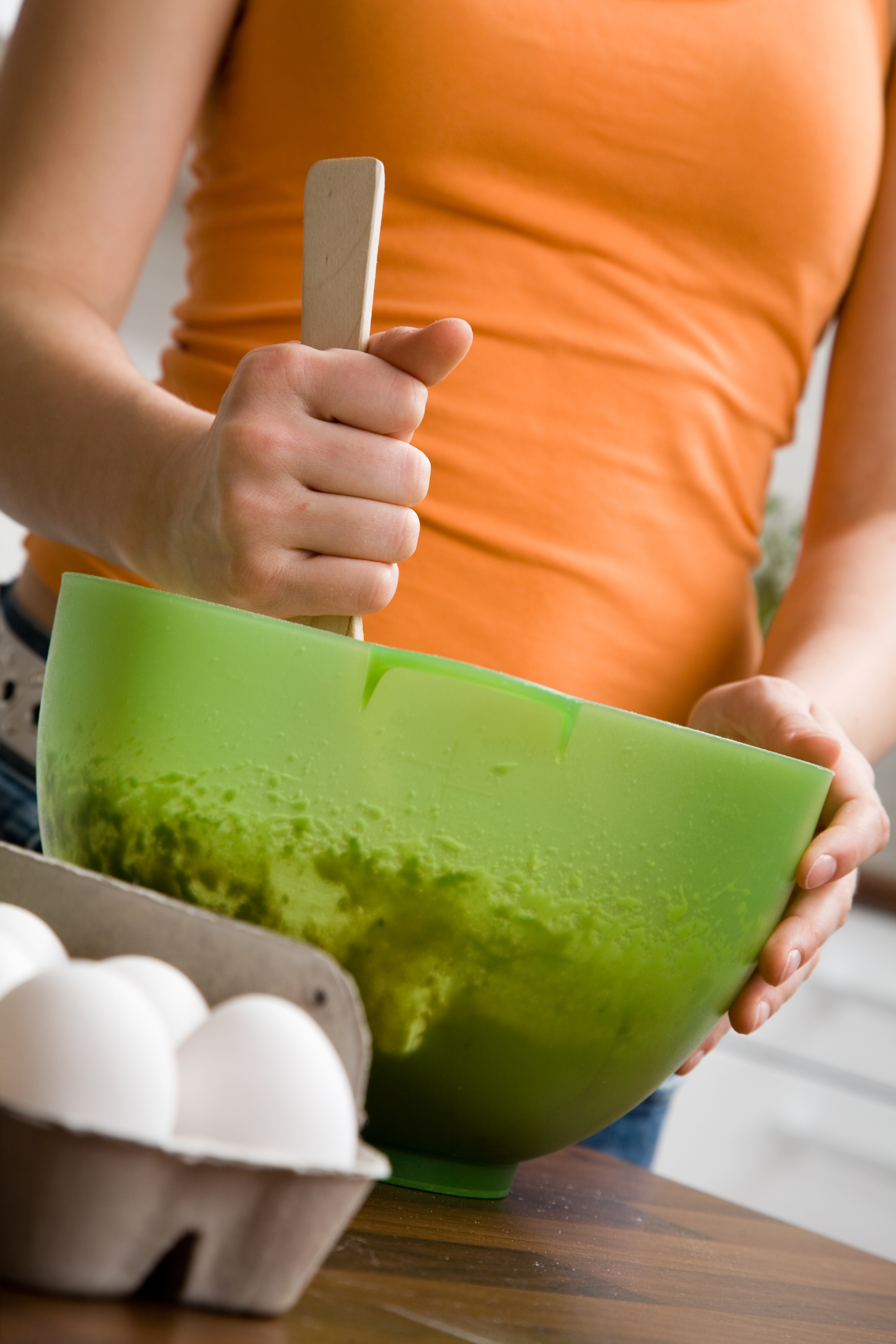 person stirring bowl of batter